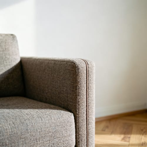 Dreisitzer-Sofa mit Cordbezug und Holzfüßen vor einer hellen Wand
