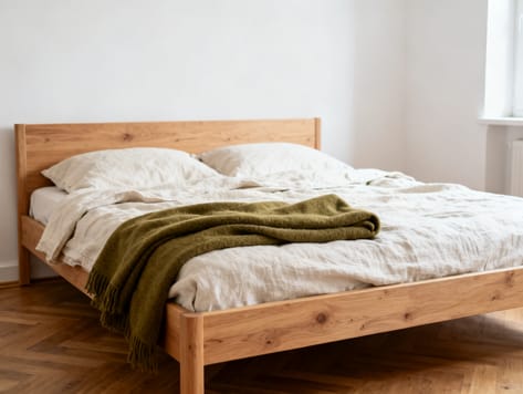 Bett mit gepolstertem Kopfteil und heller Leinenbettwäsche in einem ruhigen Schlafzimmer